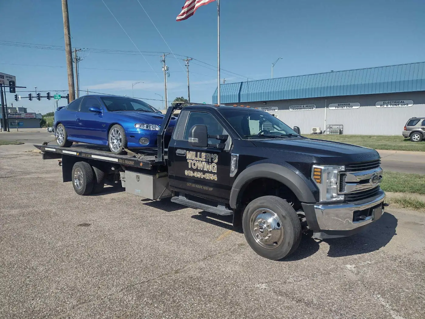 Miller's flatbed carrying a car, the type of truck used for towing near McConnell AFB