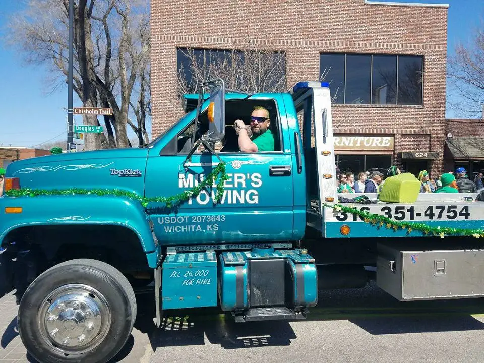 Miller's Towing driver waving from a branded tow truck in Wichita