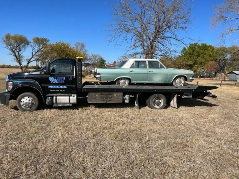 Miller's Towing flatbed transporting a classic green sedan in Wichita