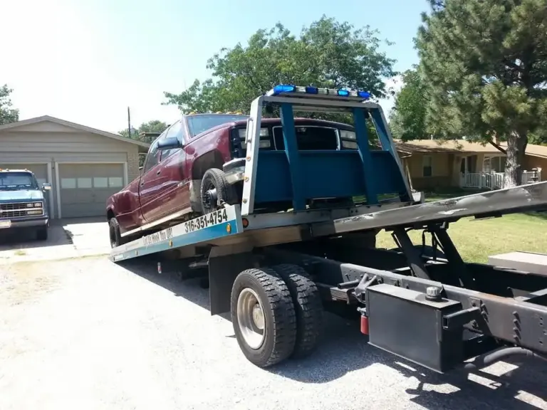 Miller's Towing flatbed loading a red car from a Wichita driveway